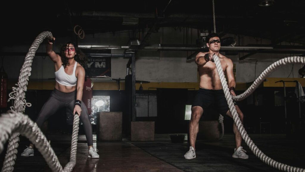 Man and woman workout at a gym side by side