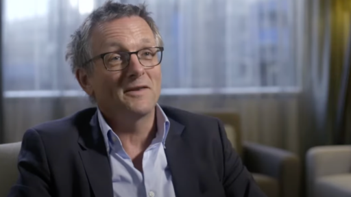 Dr Michael Moseley sits in an armchair, wearing glasses