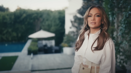 Jennifer Lopez wears a white top and stands in her backyard