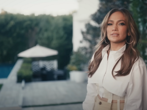 Jennifer Lopez wears a white top and stands in her backyard