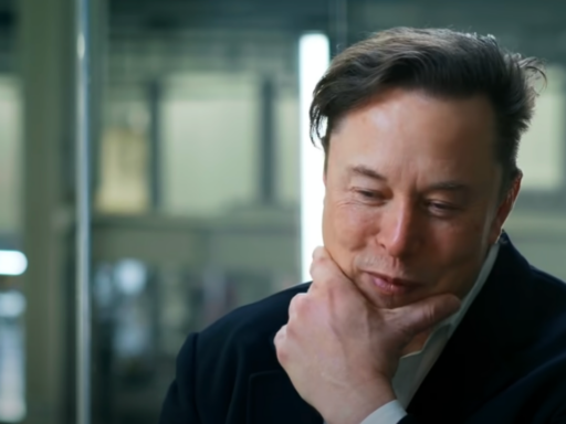 Elon Musk wears a white shirt and navy blazer