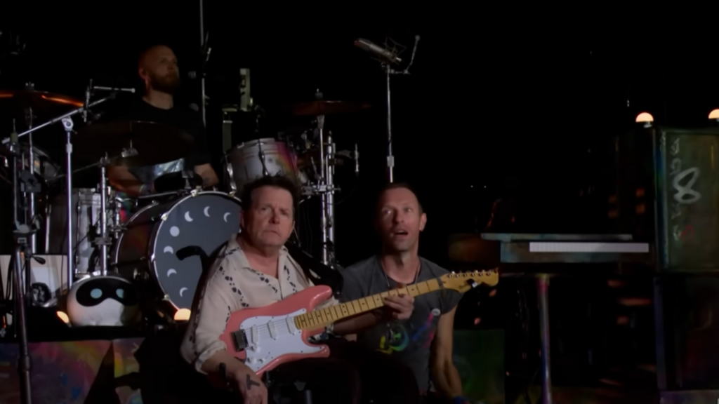 Michael J Fox playing with Coldplay on stage at Glastonbury