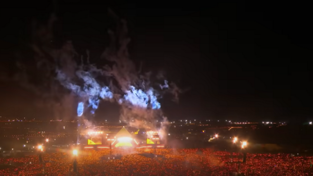 Michael J Fox playing with Coldplay on stage at Glastonbury